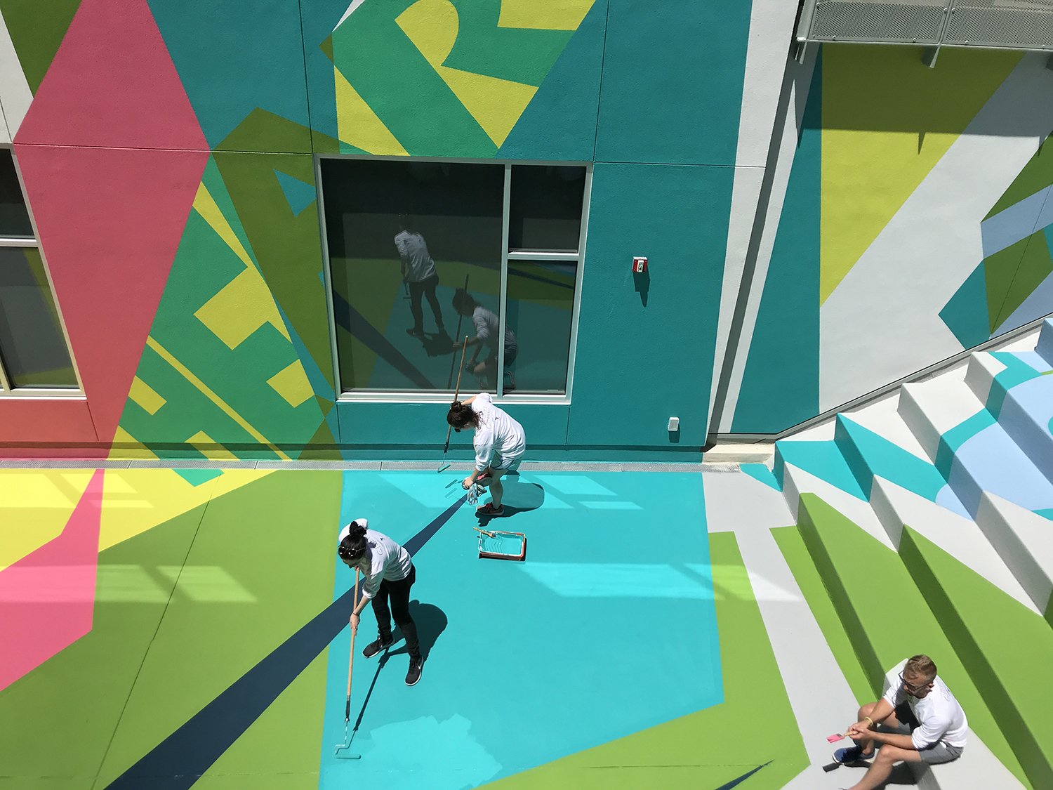Community members painting a colorful Project Color Corps transformation
